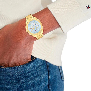 Γυναικείο ρολόι Tommy Hilfiger Mellie 1782783 με χρυσό ατσάλινο μπρασελέ και γαλάζιο καντράν 35mm με ζιργκόν, φορεμένο.